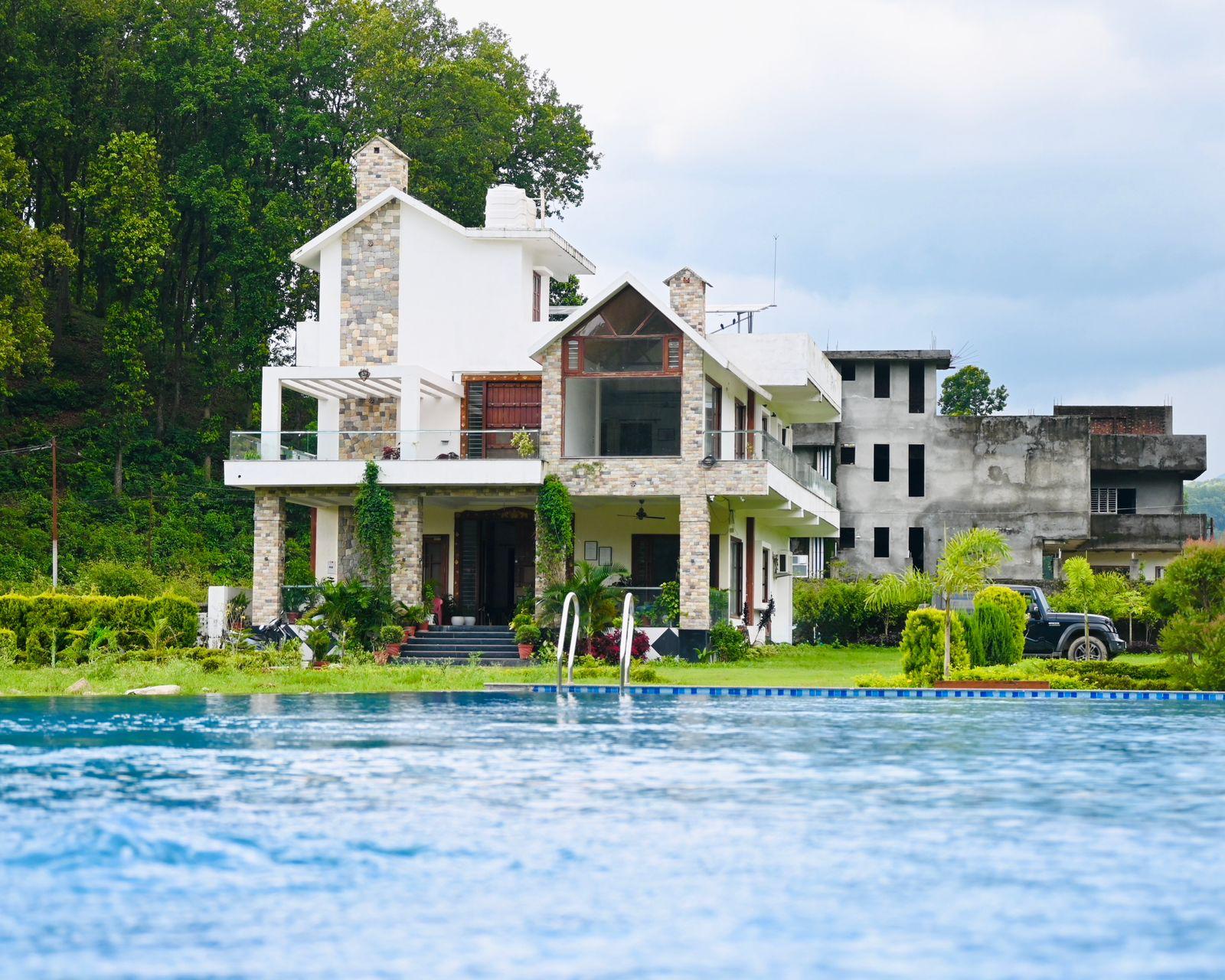 Phulsani Chitwan Retreat — the villa above its private pool, forest hillside behind